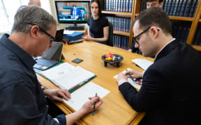 Clerk Isobel Tannock observes while Principal Clerk David Bagnall checks over Louis Donovan's paper work.
