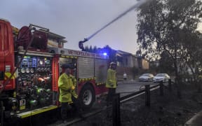 A firefighter dampens down a fire after a bushfire encroached on the outer suburbs of Melbourne on December 30, 2019.