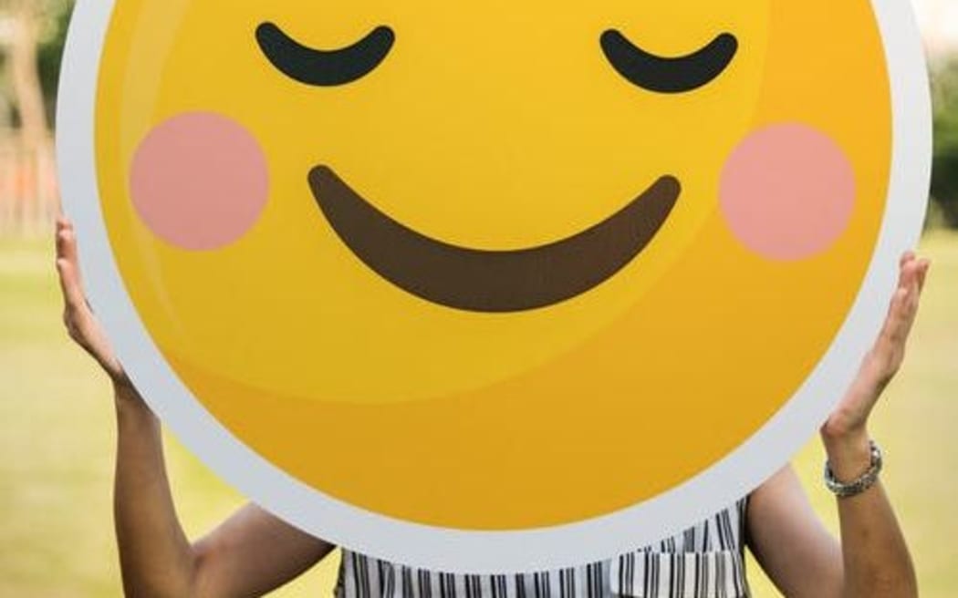 woman holding smiley face