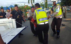 Indonesian police and security forces gather the body of West Papuan teenager Owen Pekei.