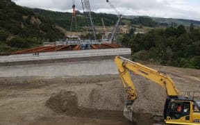 Problems under the piles for this bridge over a wetland are one of the reasons the new road's opening date has pushed out.