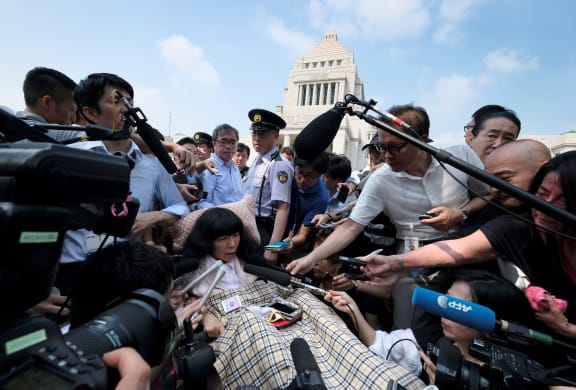 Japanese lawmaker Eiko Kimura is surrounded by the media upon her arrival at Parliament in Tokyo on 1 August, 2019.