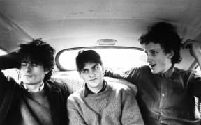 The Clean pulling faces in the back of a car