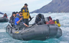 Dylan Tellei of Palau in a zodiac zipping through ice-filled water in northern Canada.