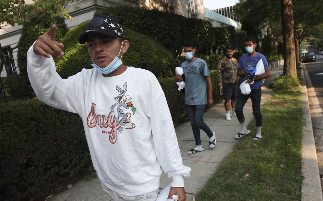 WASHINGTON, DC - SEPTEMBER 15: Migrants from Central and South America wait near the residence of US Vice President Kamala Harris after being dropped off on September 15, 2022 in Washington, DC. Texas Governor Greg Abbott dispatched buses carrying migrants from the southern border to Harris' home early Thursday morning.   Kevin Dietsch/Getty Images/AFP (Photo by Kevin Dietsch / GETTY IMAGES NORTH AMERICA / Getty Images via AFP)