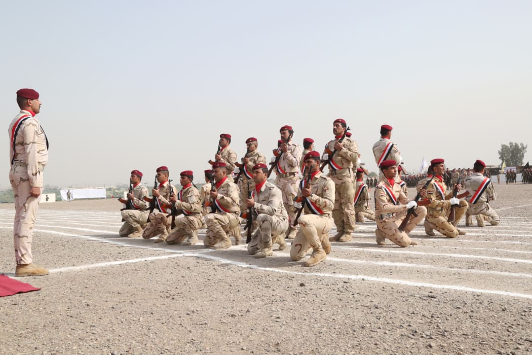 Iraqi Army soldiers fire a volley of blank rounds to begin the graduation ceremony of the Iraqi Army's Non-Commissioned Officers' Academy Junior Leaders Course at Taji Military Complex, Iraq.