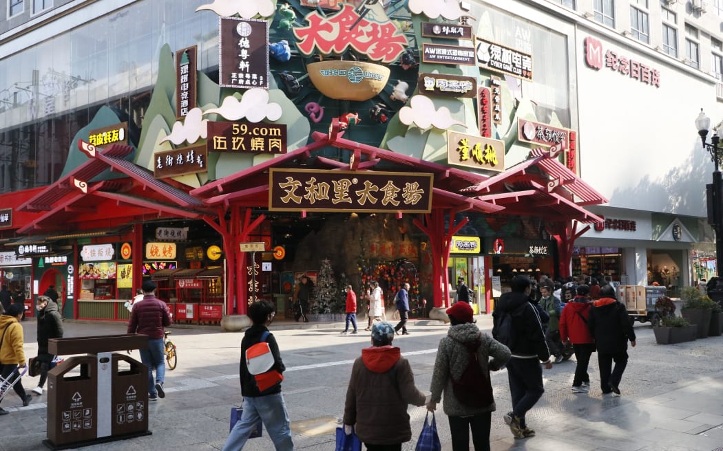 WUHAN, CHINA - DECEMBER 30: People walk at the street of Wuhan city where coronavirus (Covid-19) first discovered and spread all around the world, on December 30, 2021 in China. Emre Aytekin / Anadolu Agency (Photo by Emre Aytekin / ANADOLU AGENCY / Anadolu Agency via AFP)