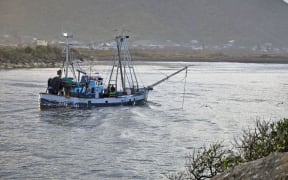 A fishing boat enters the Grey River after negotiating the notoriously dangerous crossing.