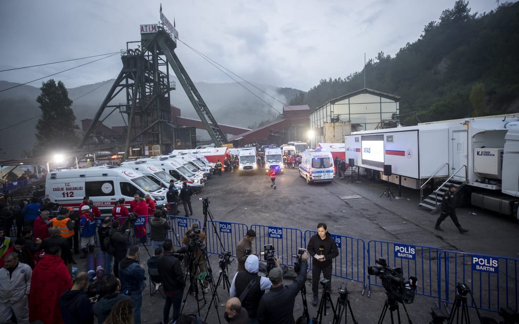 Smoke rises over the mine, and ambulances are lined up on standby for the coal miners trapped under the rubble at the explosion site, during the search and rescue operation.