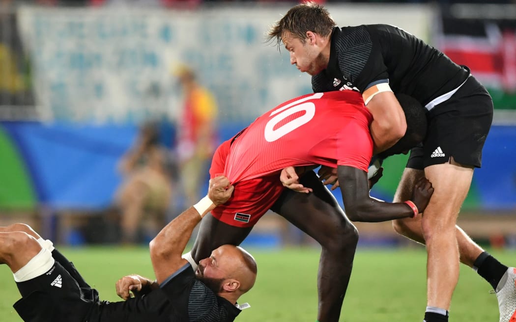New Zealand's D J Forbes (L) and New Zealand's Tim Mikkelson (R) tackle Kenya's Bush Mwale in the men’s rugby sevens match between New Zealand and Kenya during the Rio 2016 Olympic Games.
