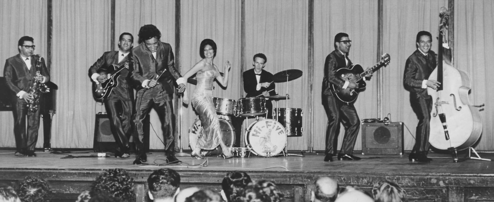 The Hi-Fives perform at the Wellington Town Hall in 1963 after returning from an international tour. From left: Kawana Pohe (saxophone), Paddy Te Tai (guitar), Solomon Pohatu (microphone), Mere Nimmo (singer), Peter Wolland (drums), Rob Hemi (guitar) and Wes Epae (bass).