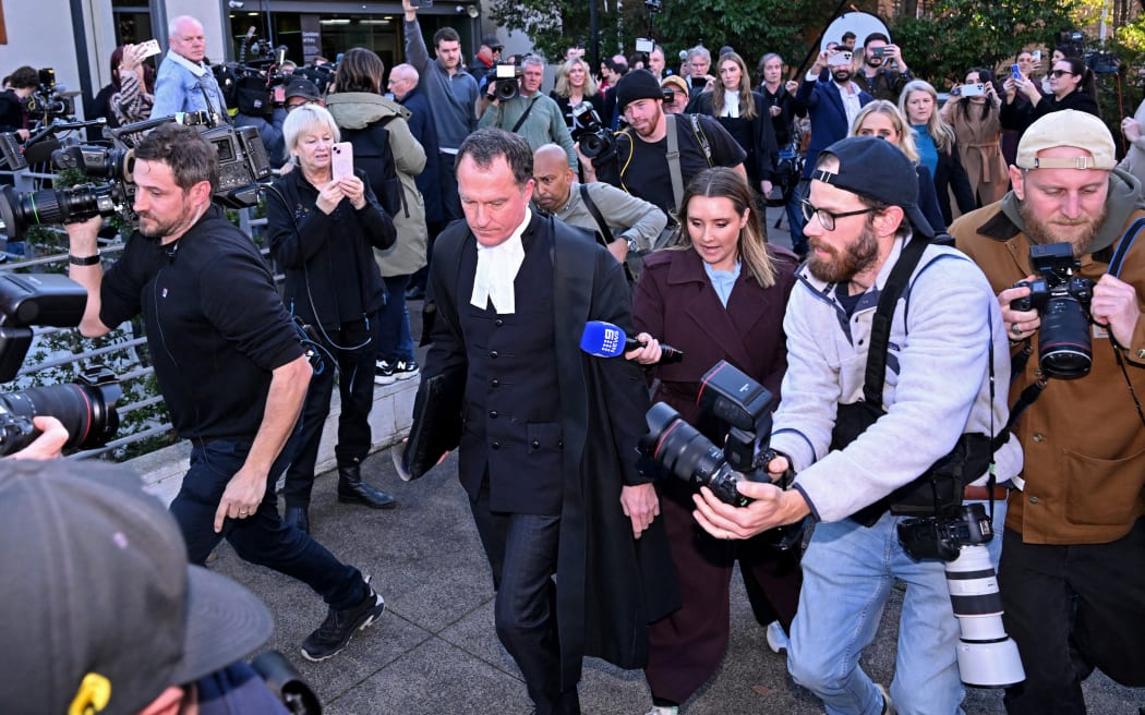 Lead barrister Colin Mandy (C) is surrounded by members of the media as he leaves the Latrobe Valley Magistrates' Court in Morwell on July 7, 2025. An Australian woman murdered her husband's parents and aunt by lacing their beef Wellington lunch with toxic mushrooms, a jury found on July 7 at the climax of a trial watched around the world. Keen home cook Erin Patterson hosted an intimate meal in July 2023 that started with good-natured banter and earnest prayer -- but ended with three guests dead. (Photo by WILLIAM WEST / AFP)