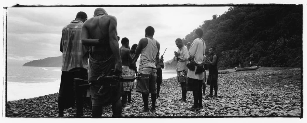 Harold Keke (centre, praying) and his GLF guerillas pray on a beach before patrolling, along the Weathercoast, Guadalcanal, Solomon Islands,
2003