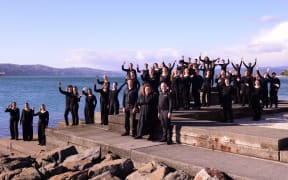 New ZEaland Youth Choir pose in front of an identified harbour location