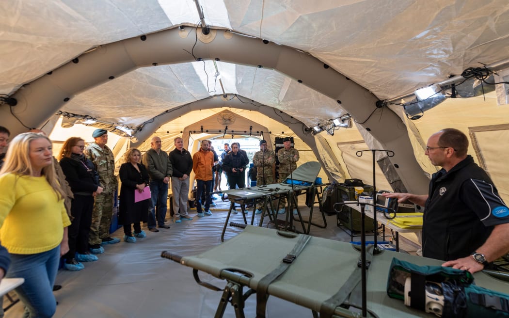 The New Zealand Medical Assistance Team's Dr Alan Goodey explaining the inner workings of the triage area in the deployable health facility setup.  27 October 2023 Trentham Military Base, Upper Hutt, Wellington.