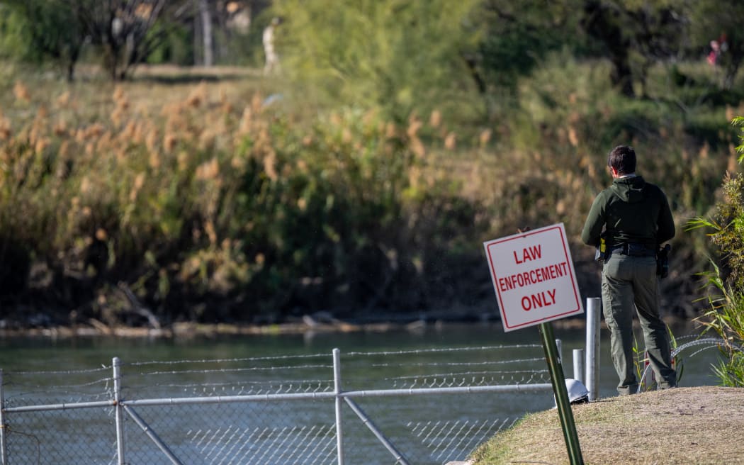 EAGLE PASS, TEXAS - JANUARY 12: An officer stands guard on the banks of the Rio Grande river at Shelby Park on January 12, 2024 in Eagle Pass, Texas. The Texas National Guard continues its blockade and surveillance of Shelby Park in an effort to deter illegal immigration. The Department of Justice has accused the Texas National Guard of blocking Border Patrol agents from carrying out their duties along the river.   Brandon Bell/Getty Images/AFP (Photo by Brandon Bell / GETTY IMAGES NORTH AMERICA / Getty Images via AFP)