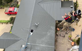 An NH90 helicopter and crew recover people from the rooftops of their homes in Esk Valley, Napier.