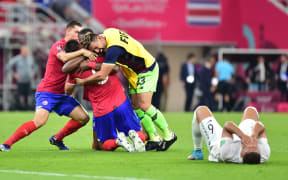 Costa Rican players celebrate beside a dejected Bill Tuiloma at the end of New Zealand All Whites v Costa Rica, FIFA World Cup 2022 play-off match at Ahmad Bin Ali Stadium, Qatar on 14 June 2022.
 © Photo: Tom Kirkwood/www.photosport.nz