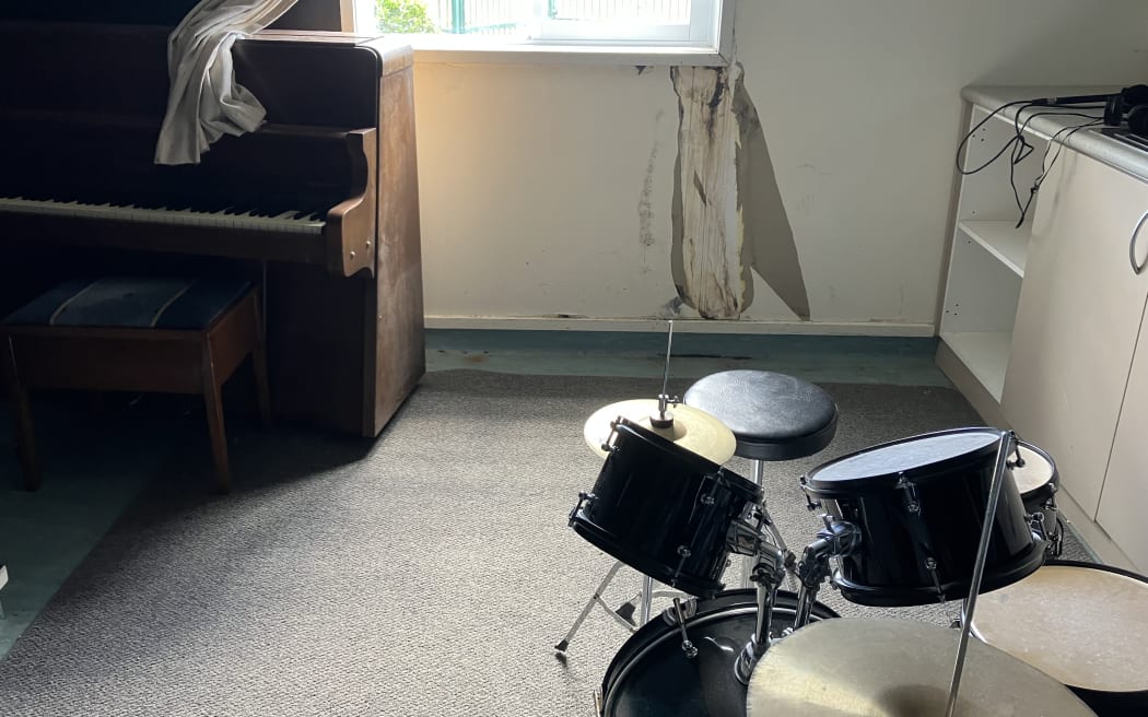 Mould eating away under a window in a room partly used as a music therapy space