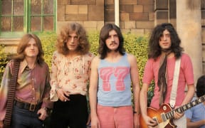 A 60s photo of the band Led Zeppelin with long hair and colourful clothes at Bath Festival, 1969