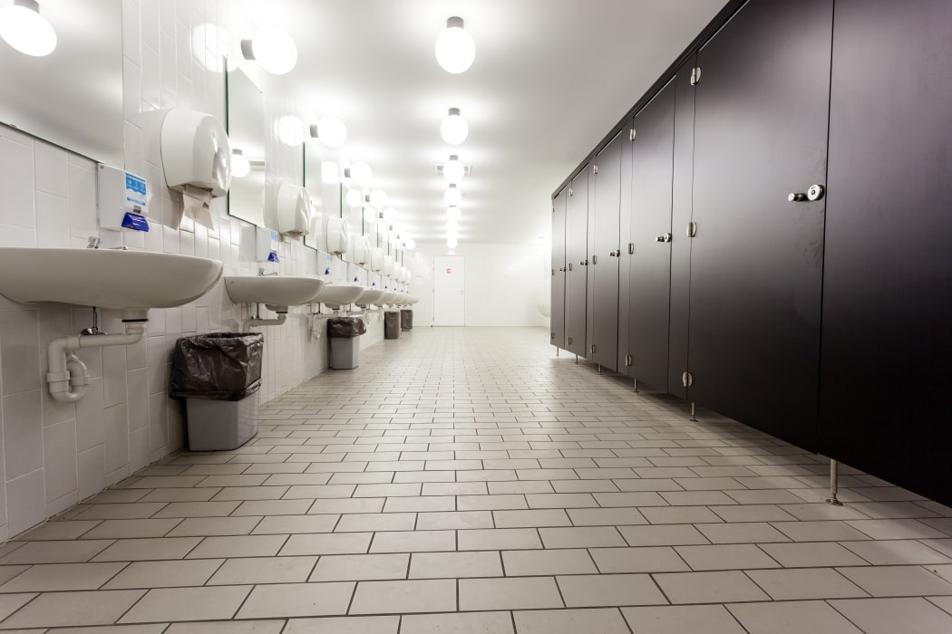 Mens restroom in an public building in white and black doors