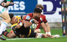 Crusaders Richie Mo'unga Scores a try with Hurricanes' Ardie Savea holding on.