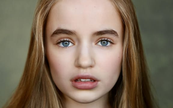 Nell Fisher is a young girl with pale skin, long brown hair and blue eyes.