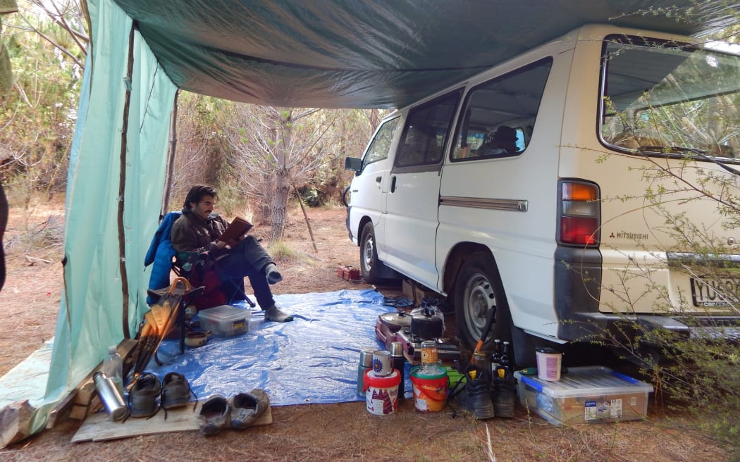 Author Warwick Stubbs setting up camp outside the van he writes about in his book Two Left Feet