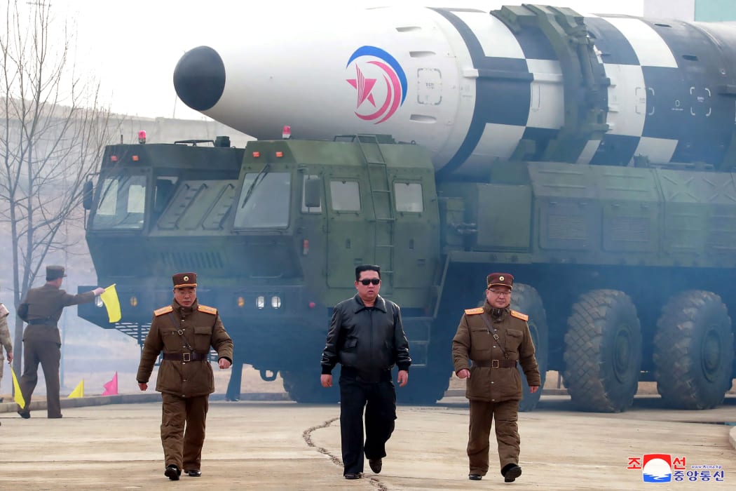 This picture taken on March 24, 2022 and released from Korean Central News Agency on March 25, 2022 shows North Korean leader Kim Jong Un (centre) walking near what state media report says is a new type inter-continental ballistic missile (ICBM), Hwasongpho-17.
