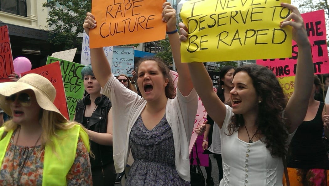 Michaela Housiaux-Andrews, 18, and Isobel Gledhill, 19, chant beneath their placards.