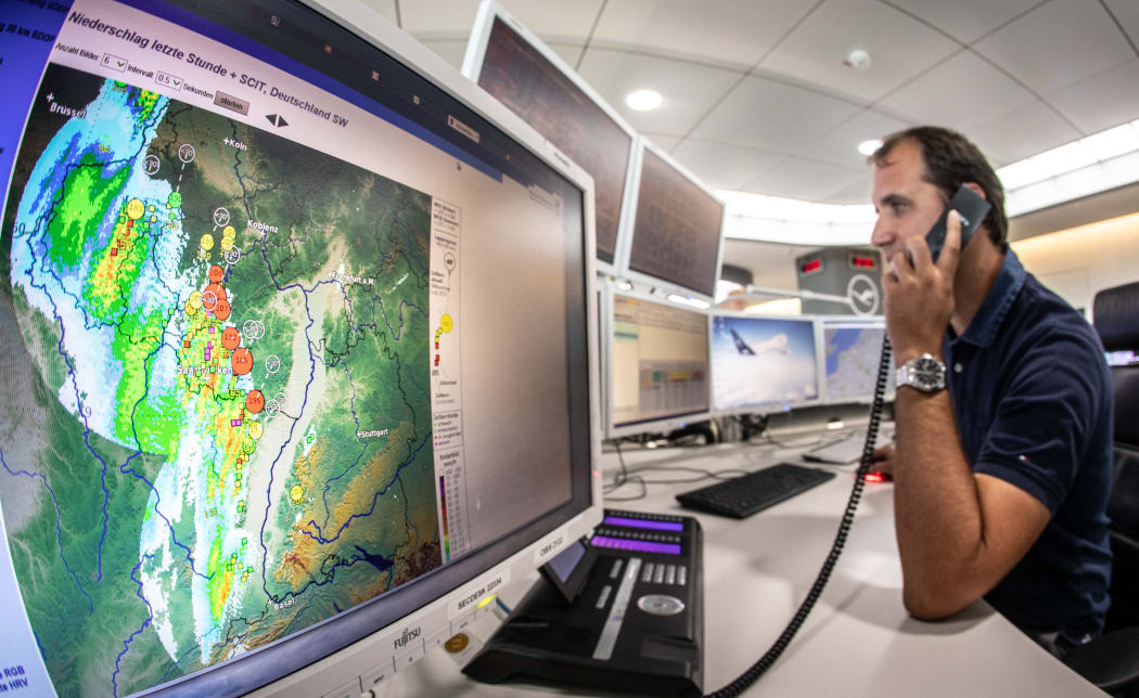 09 August 2018, Germany, Frankfurt am Main: Thomas Fenske, shift manager at Lufthansa's operational control center, is planning to reschedule or even cancel flights in view of an approaching storm front (weather radar on a screen on the left). Frankfurt Airport temporarily suspended flight operations in the afternoon due to the storm front. Photo: Frank Rumpenhorst/dpa (Photo by FRANK RUMPENHORST / DPA / dpa Picture-Alliance via AFP)