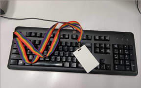 Image of a rainbow lanyard sitting on a keyboard