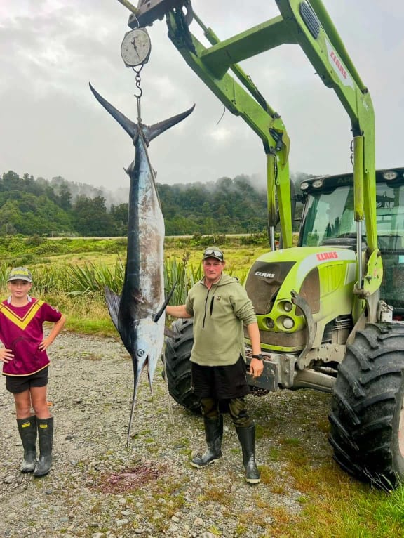 Ryan Mawdsley, right, with the 70kg striped marlin he caught off Jackson's Bay on the West Coast.