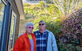 Julie Ambrose and Geoff Moffett with the exposed slope behind their home.