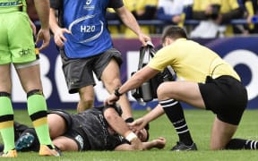 The referee (R) tends to Clermont's French scrum-half Morgan Parra (Bottom) suffering from concussion during the European Rugby Champions Cup match ASM Clermont Auvergne vs Northampton Saints at the Marcel-Michelin stadium in Clermont-Ferrand