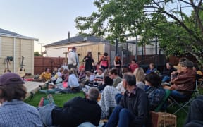 Cast members of A Midsummer Night’s Dream follow Puck through the crowd during a backyard show in Nelson.