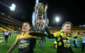 Hurricanes' TJ Perenara & Beauden Barrett hold the Super Rugby Trophy aloft 2016.