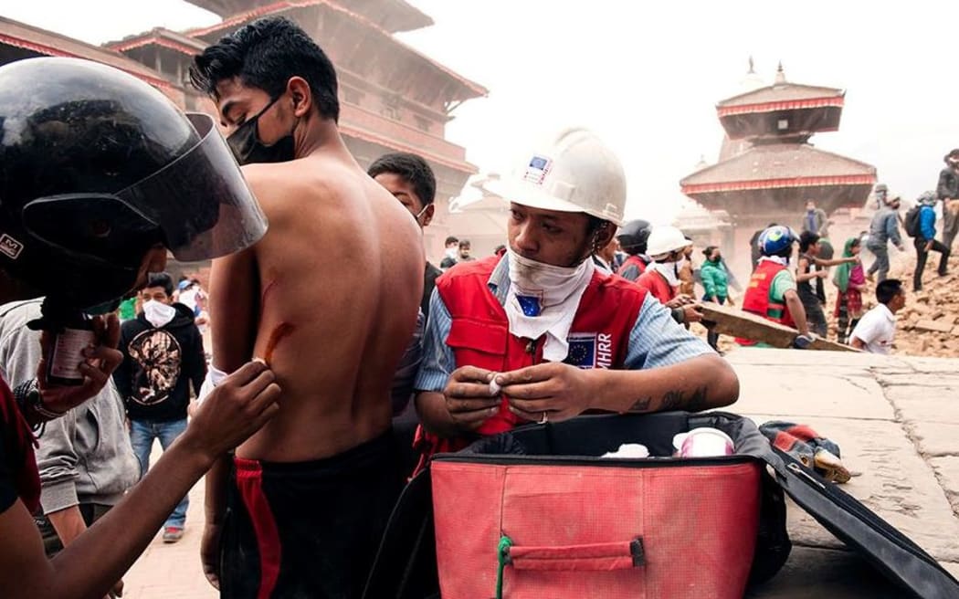 Red Cross workers assist a man in Nepal.