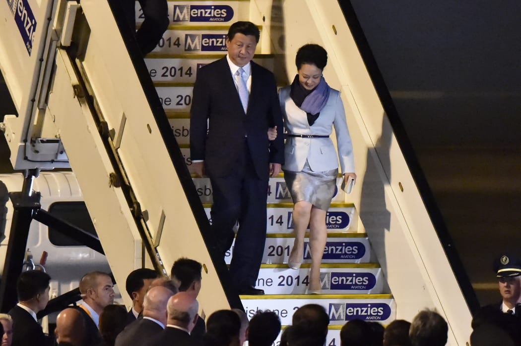 China's President Xi Jinping and his wife Peng Liyuan walk down from their plane upon their arrival in Brisbane.