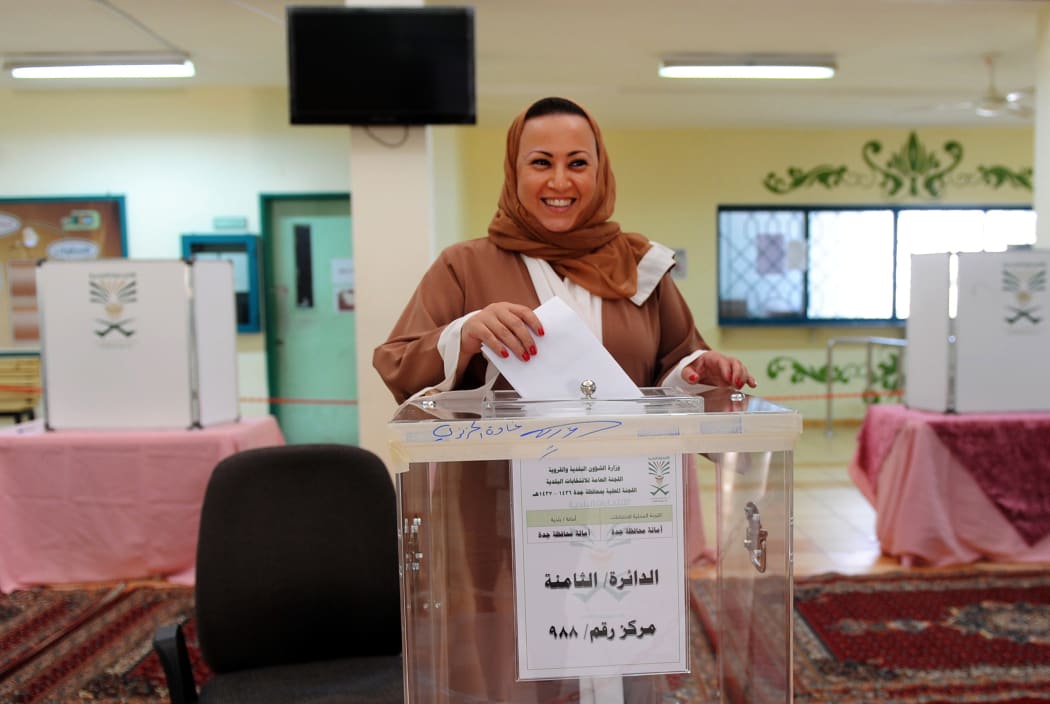 A Saudi woman arrives at a polling station to vote for the municipal elections