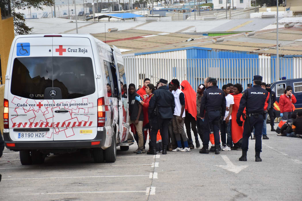 Migrants queue to board a Red Cross bus in El Tarajal, Ceuta, close to the border with Morocco on 9 December, 2016 after being rounded up by police.
