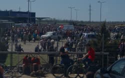 People gather to receive humanitarian aid in a car park in Mariupol on 29 April.
