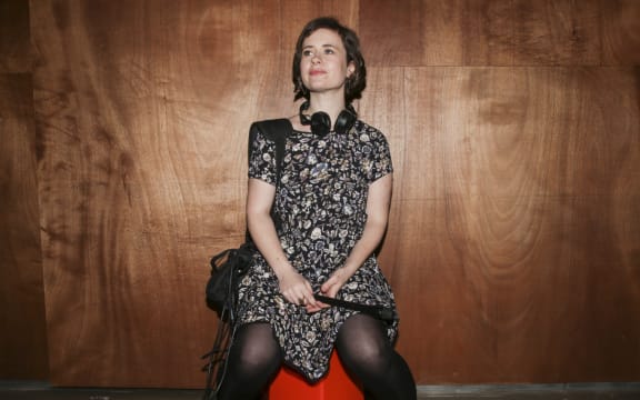 A portrait of Bang! producer and presenter Melody Thomas, wearing headphones and carrying a recording device.