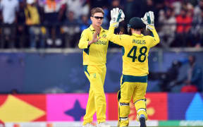 Australia's Adam Zampa (L) celebrates the wicket of New Zealand's Daryl Mitchell during their group match at the Cricket world Cup.