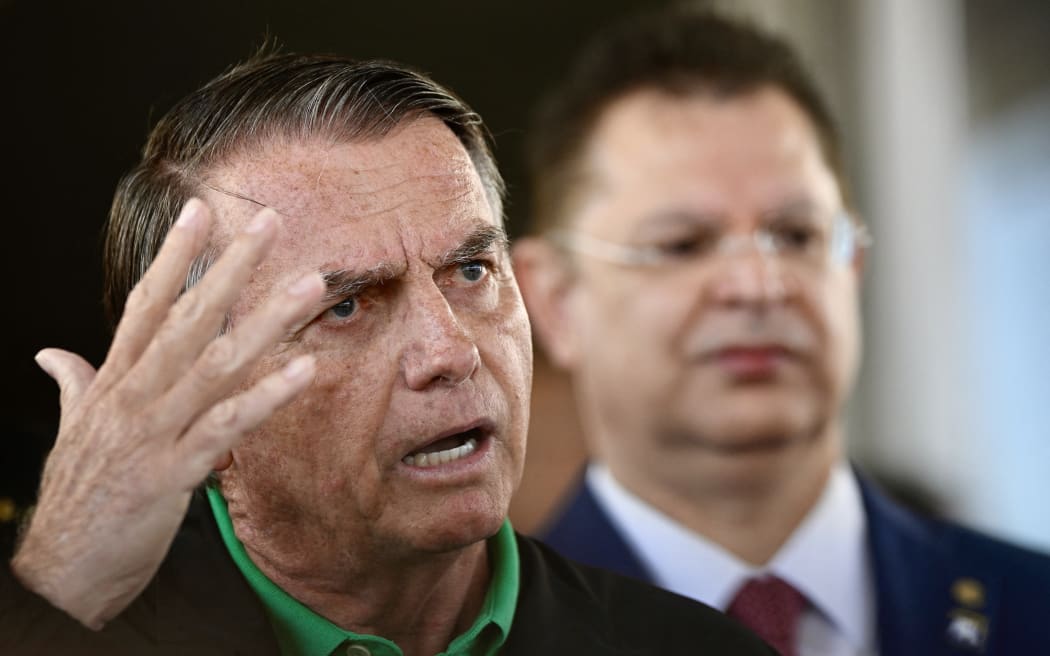 Former Brazilian President Jair Bolsonaro speaks to the press at the Federal Senate in Brasilia on July 17, 2025. A prosecutor asked Brazil's Supreme Court on Tuesday to find Bolsonaro guilty of plotting a coup, in closing arguments after a trial that saw US President Donald Trump try to intervene on behalf of his right-wing ally. (Photo by Mateus Bonomi / AFP)