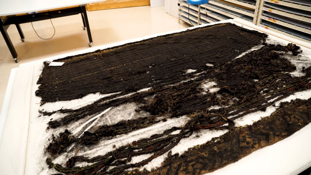 Deterioration of cloak made from dyed black muka (flax fibre).