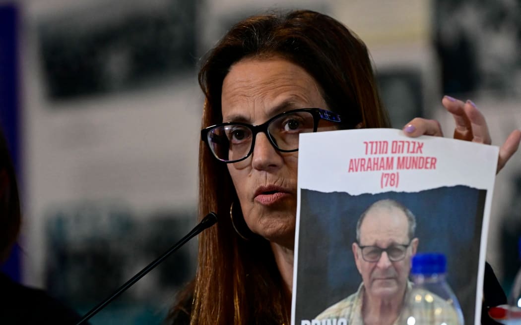 Israeli citizen Merav Mor Raviv holds a sign depicting Avraham Munder, 78, held hostage by Hamas militants following the October 7 attack, during a press conference by families of Israelis citizen held captives, at the Jewish Community of Madrid building, in Madrid on October 26, 2023. Thousands of civilians, both Palestinians and Israelis, have died since October 7, 2023, after Palestinian Hamas militants based in the Gaza Strip entered southern Israel in an unprecedented attack triggering a war declared by Israel on Hamas with retaliatory bombings on Gaza. (Photo by JAVIER SORIANO / AFP)