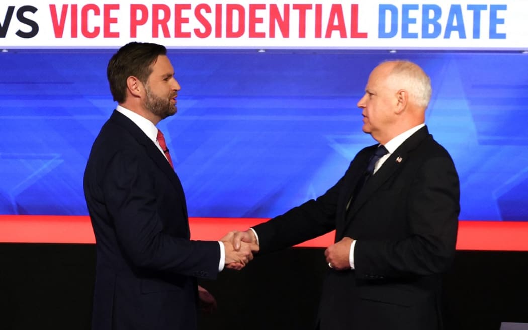 US Senator and Republican vice presidential candidate J.D. Vance (L) and Minnesota Governor and Democratic vice presidential candidate Tim Walz shake hands at the start of the Vice Presidential debate hosted by CBS News at the CBS Broadcast Center in New York City on October 1, 2024. (Photo by CHARLY TRIBALLEAU / AFP)