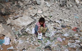 A Palestinian girl looks for salvageable items amid the destruction on the southern outskirts of Khan Yunis in the war-battered Gaza Strip on January 16, 2024, amid continuing fighting between Israel and the Palestinian militant group Hamas.
