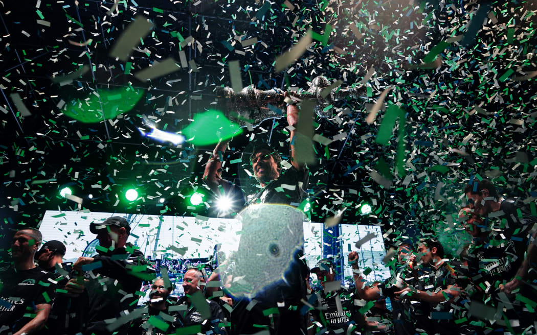 Defender Emirates Team New Zealand's co-skipper and helmsman Peter Burling (C) raises the America's Cup trophy during the trophy ceremony after winning the Louis Vuitton 37th America's Cup, in Barcelona on October 19, 2024.
